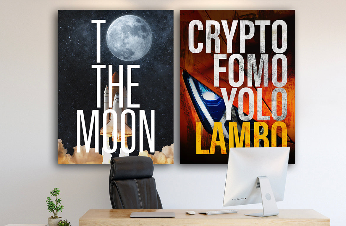 Home office with two large motivational canvas wrap wall art pieces hanging above desk. To The Moon and Crypto FOMO Yolo Lambo canvas wrap art pieces are hanging on white wall next to lamp.