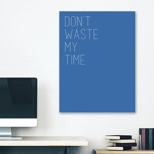 Blue minimalist canvas wrap wall art hanging on white bedroom wall with funny saying "don't waste my time"