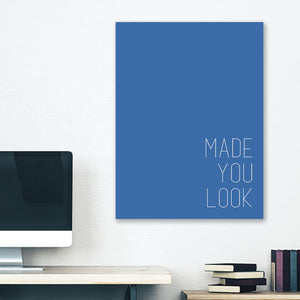 Blue minimalist canvas wrap wall art hanging on white bedroom wall with funny saying "made you look"