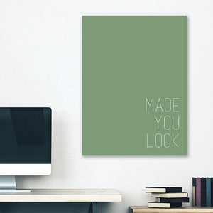 Green minimalist canvas wrap wall art hanging on white bedroom wall with funny saying "made you look"